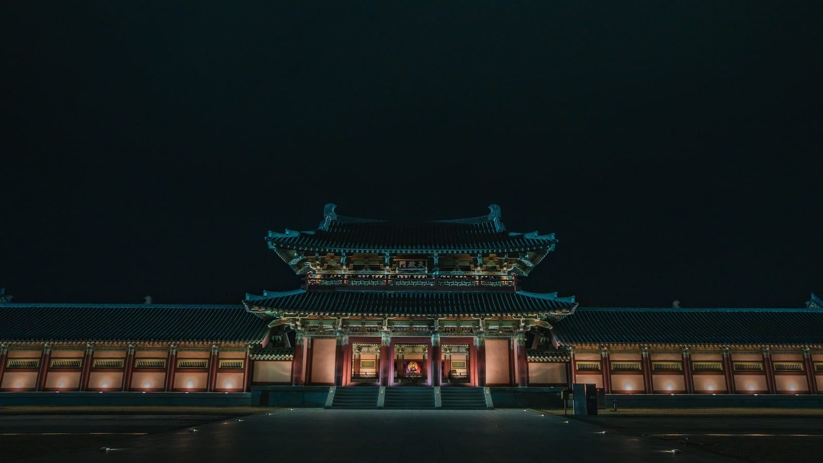 달빛 아래 고궁을 거니는 여행객과 전통 건축의 야경